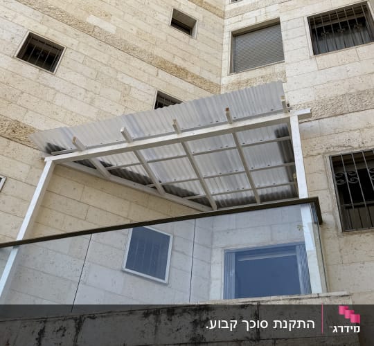 מרפסת עם סוכך מתכת על בניין אבן